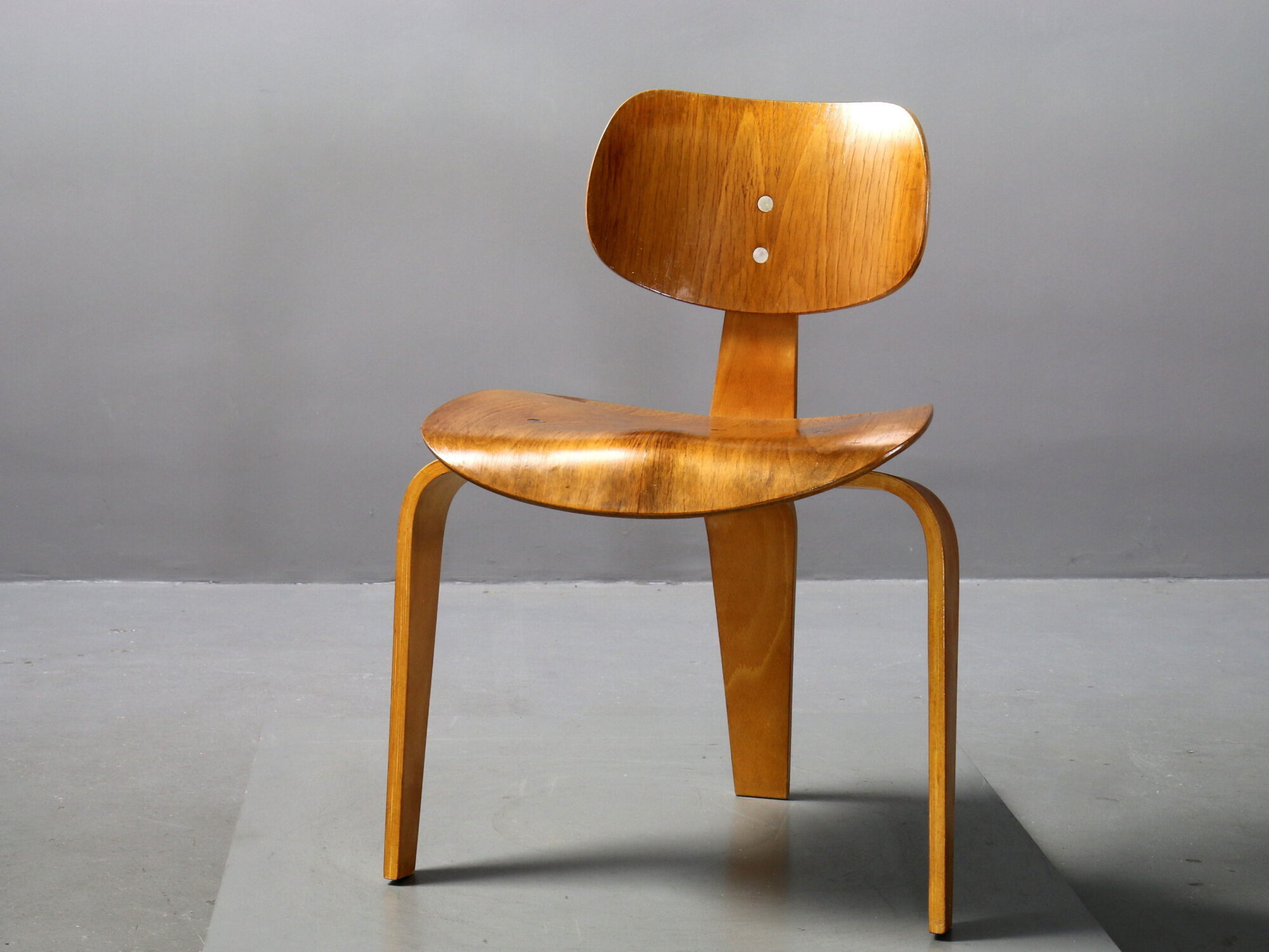 Der Eiermann Stuhl hat eine naturfarbene Oberfläche mit gebogenen Holzbeinen.